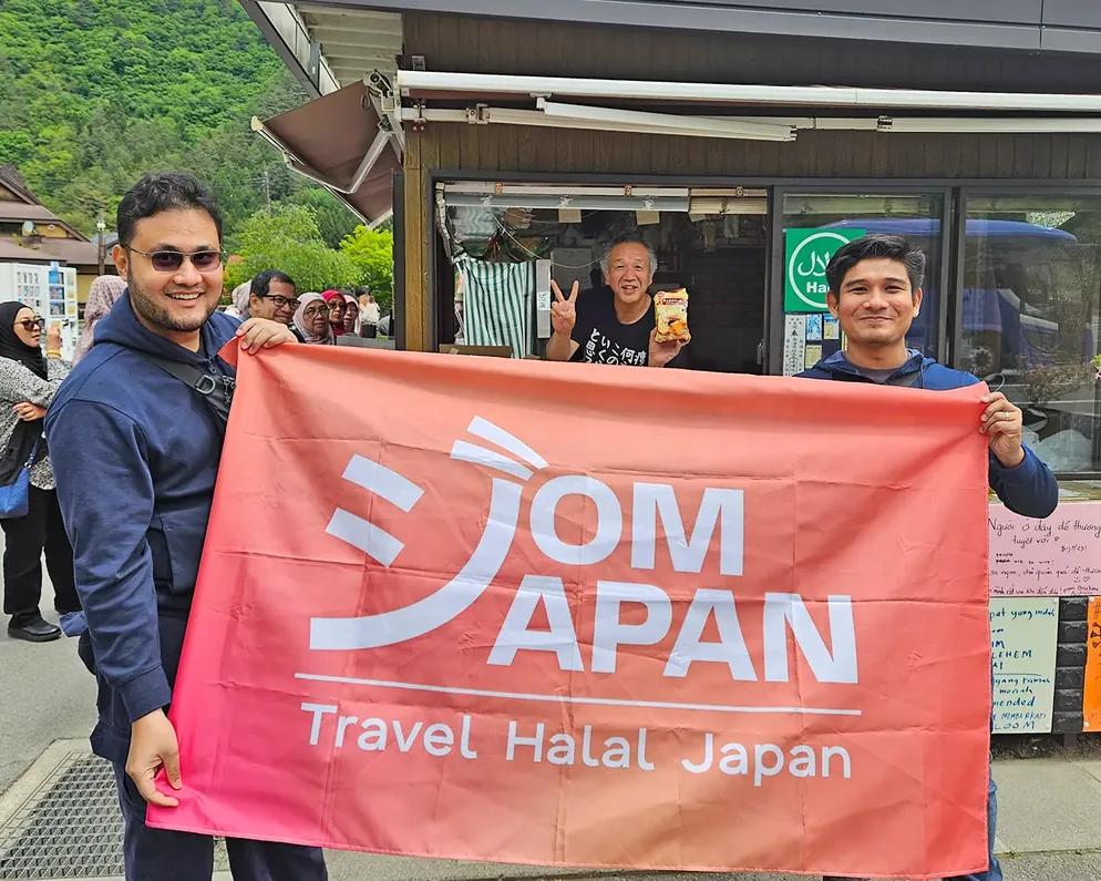 Kru JomJapan pegang sepanduk di gerai makanan halal di Jepun